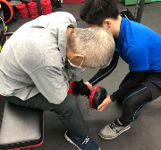 トレーナーと一緒にダンベルを持ち上げる写真