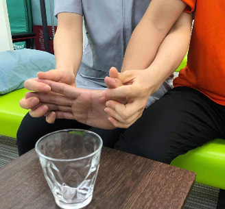 麻痺側の手でコップを持つ写真